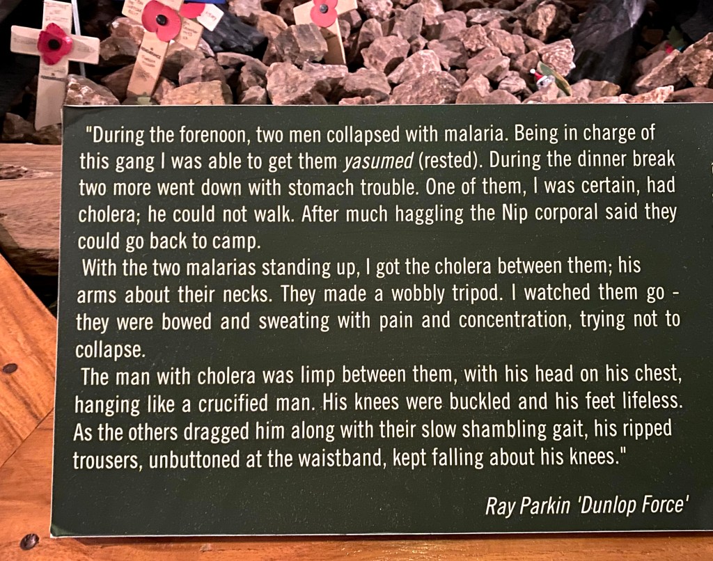 Inscription of the sculpture. Last paragraph reads: The man with cholera was limp between them, with his head on his chest, hanging like a crucified man. His knees were buckled and his feet lifeless. As the others dragged him along with their slow shambling gait, his ripped trousers, unbuttoned at the waistband, kept falling about his knees.