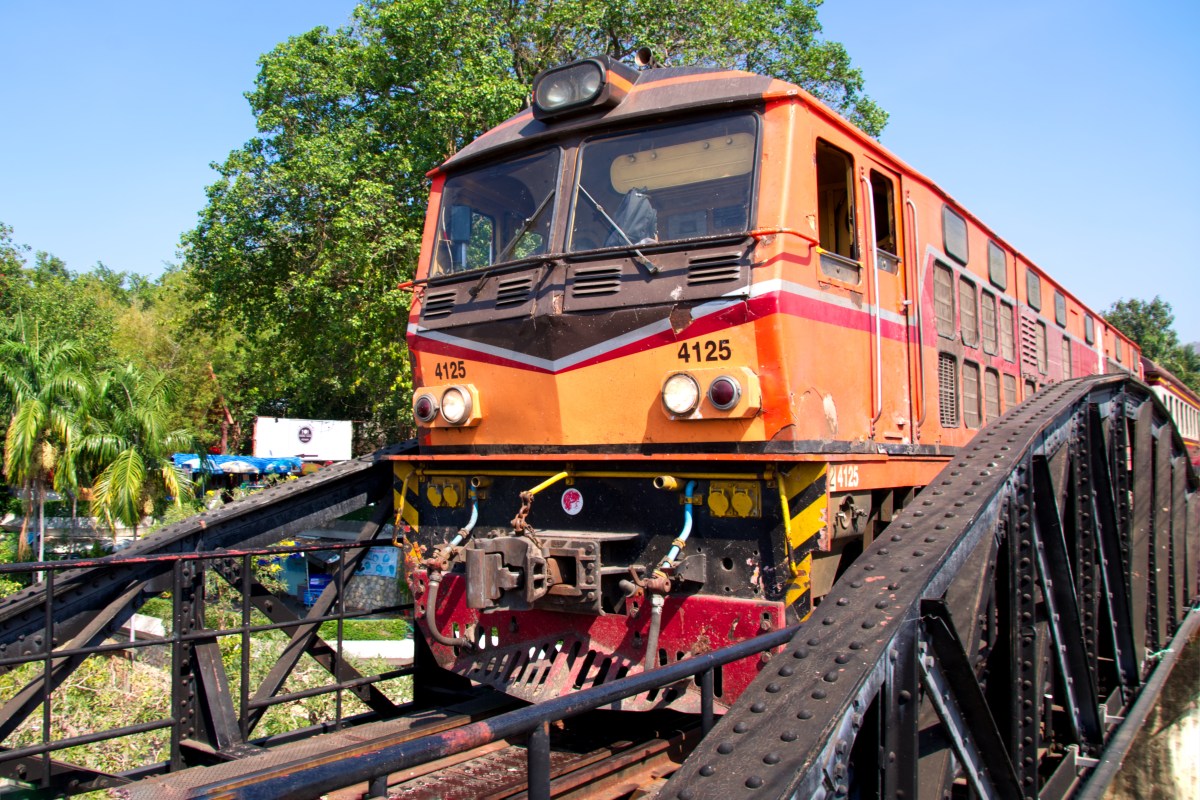 Train moving slowly over the bridge on the River Kwai